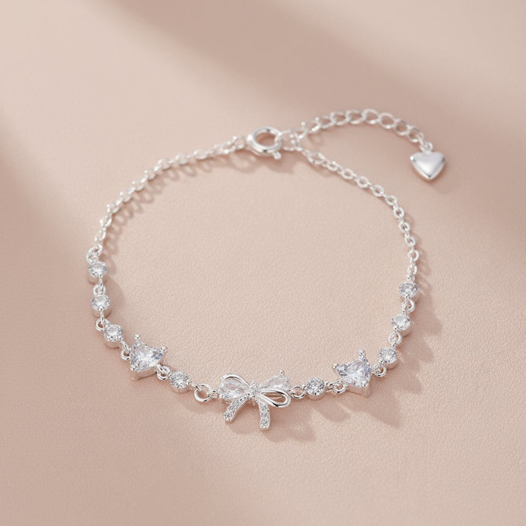 Silver bracelet with bow and crystal details on a beige background