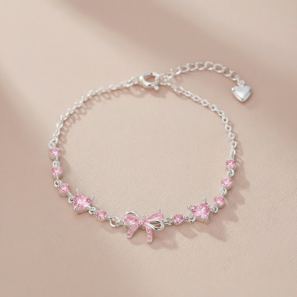 Silver bracelet with pink bow and crystals on a beige background