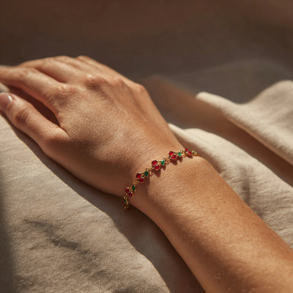 Hand wearing a bracelet with red and green beads on a beige surface