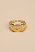 Gold ring with a diamond on a beige background