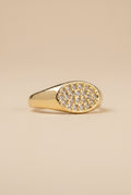 Gold ring with diamond accents on a beige background