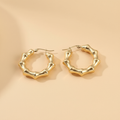 Gold hoop earrings on a beige background