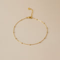 Gold bracelet on a beige background
