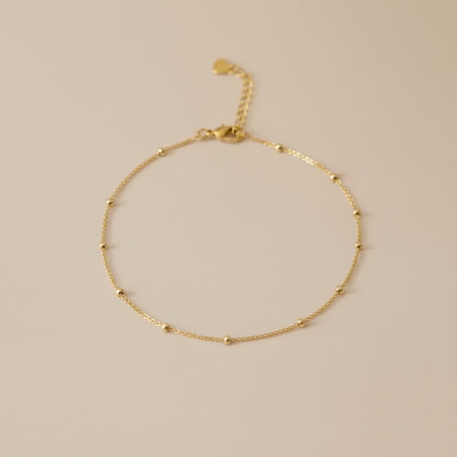 Gold bracelet on a beige background