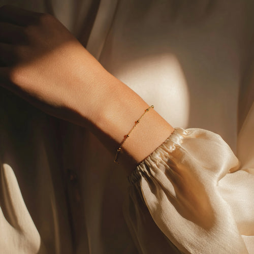 Close-up of a wrist wearing a gold bracelet with a soft focus background