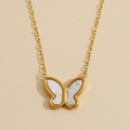 Gold butterfly necklace on a beige background