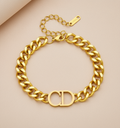 Gold chain bracelet on a beige background