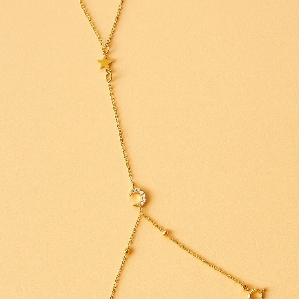 Gold Handchain with star and moon pendants on a yellow background