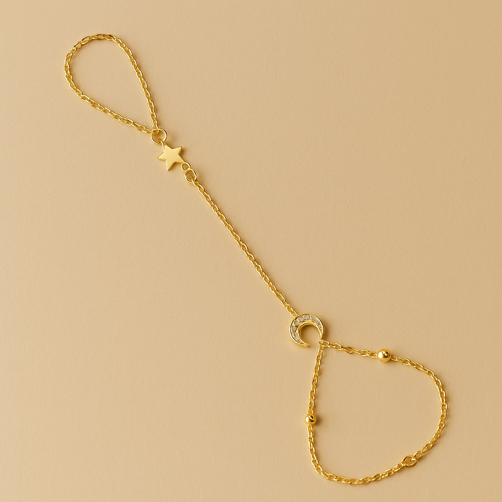 Gold Celestial Handchain with star and circle charms on a beige background