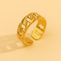 Chain-Link Gold Ring with braided design on a beige background