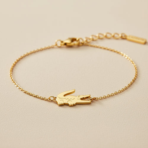 Gold bracelet with a Croc design on a beige background