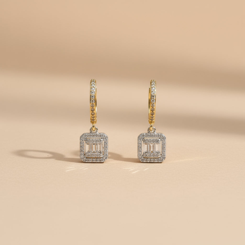 Pair of diamond earrings on a beige background