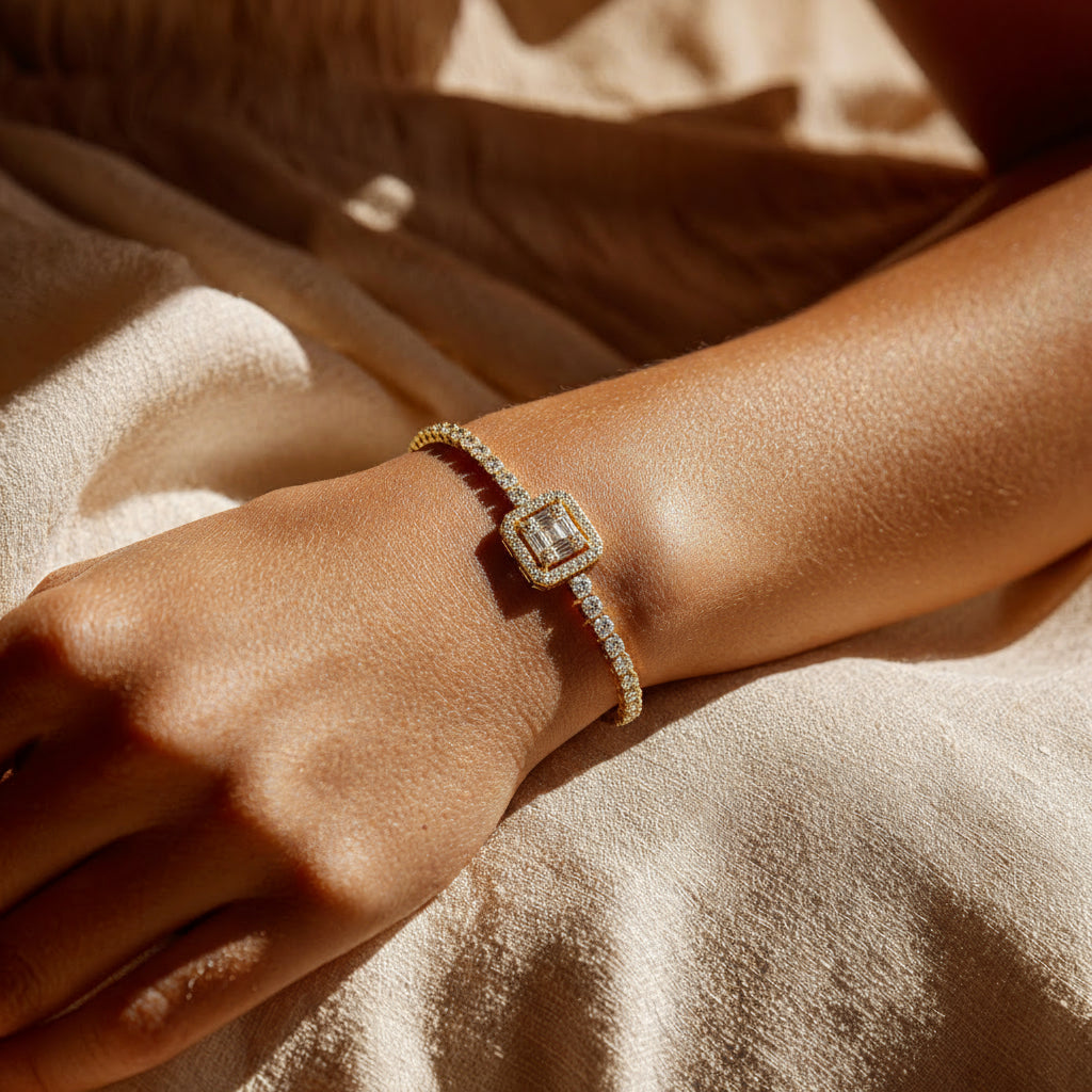 gold bracelet with a diamond on a wrist against a beige fabric background