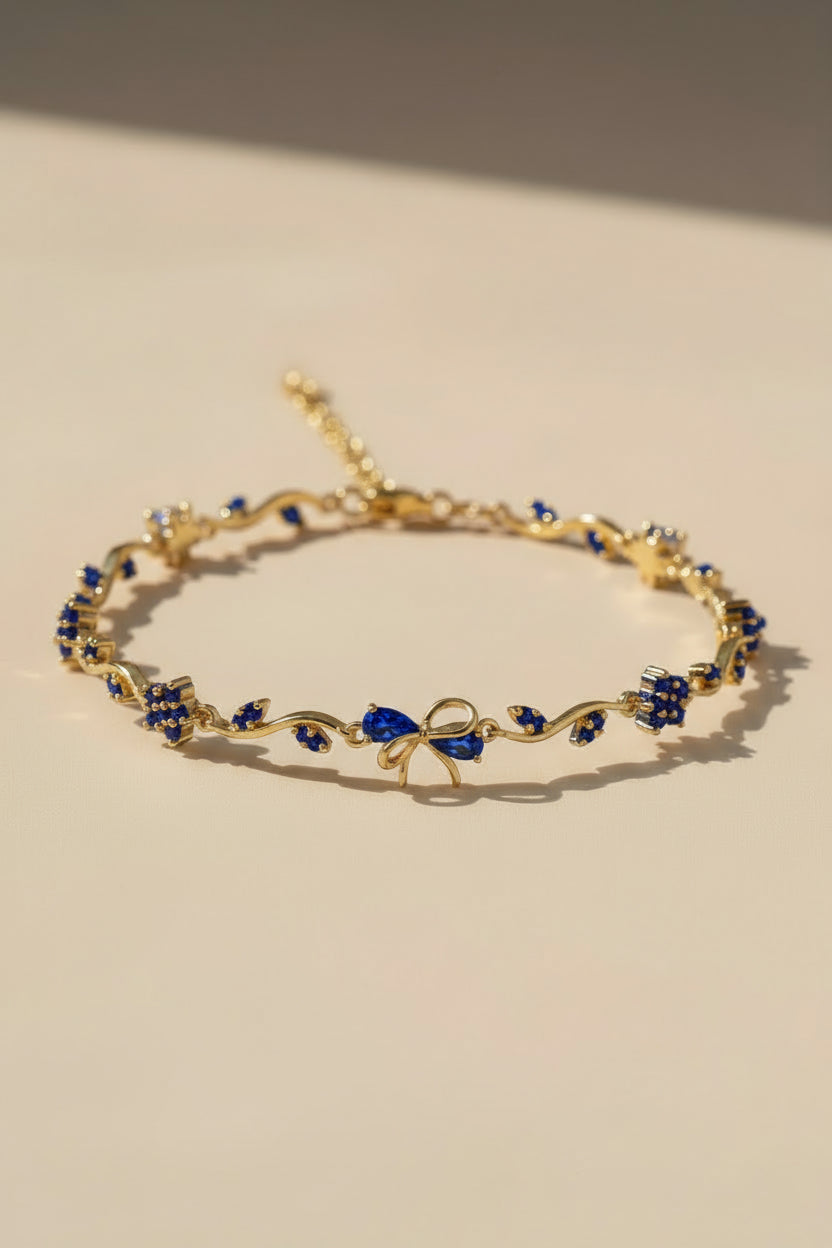 Gold bracelet with blue stones on a beige background