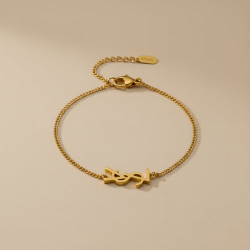 Gold bracelet with a clasp on a beige background