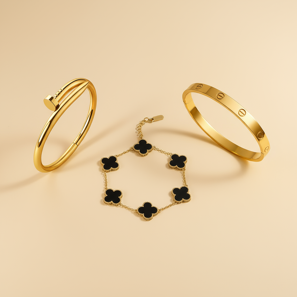 Three gold bracelets with black accents on a beige background