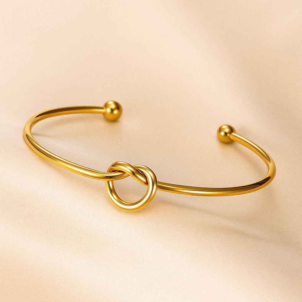 Gold bracelet with a knot design on a beige background
