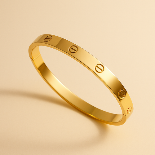 Gold bracelet with engraved design on a beige background