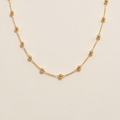 Golden Beaded Necklace on a beige background