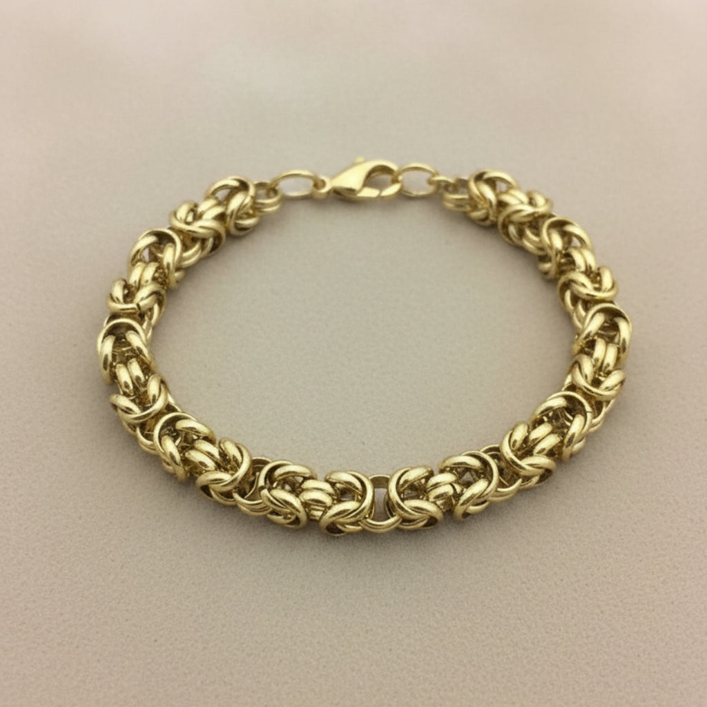 Gold chain bracelet on a beige background