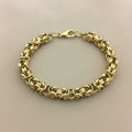 Gold chain bracelet on a beige background