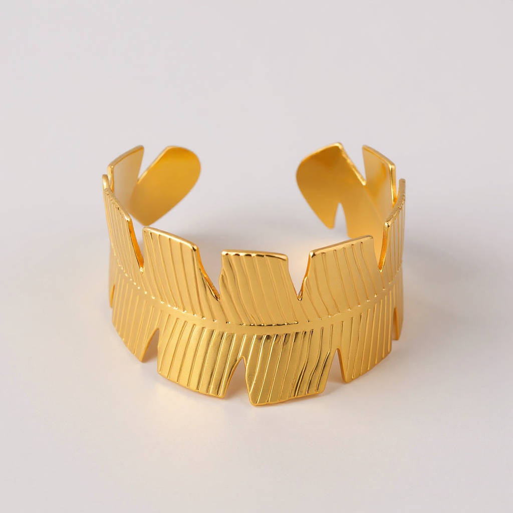 Golden Palm Bangle with a textured design on a light gray background