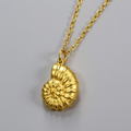 Gold necklace with a Spiral pendant on a gray background