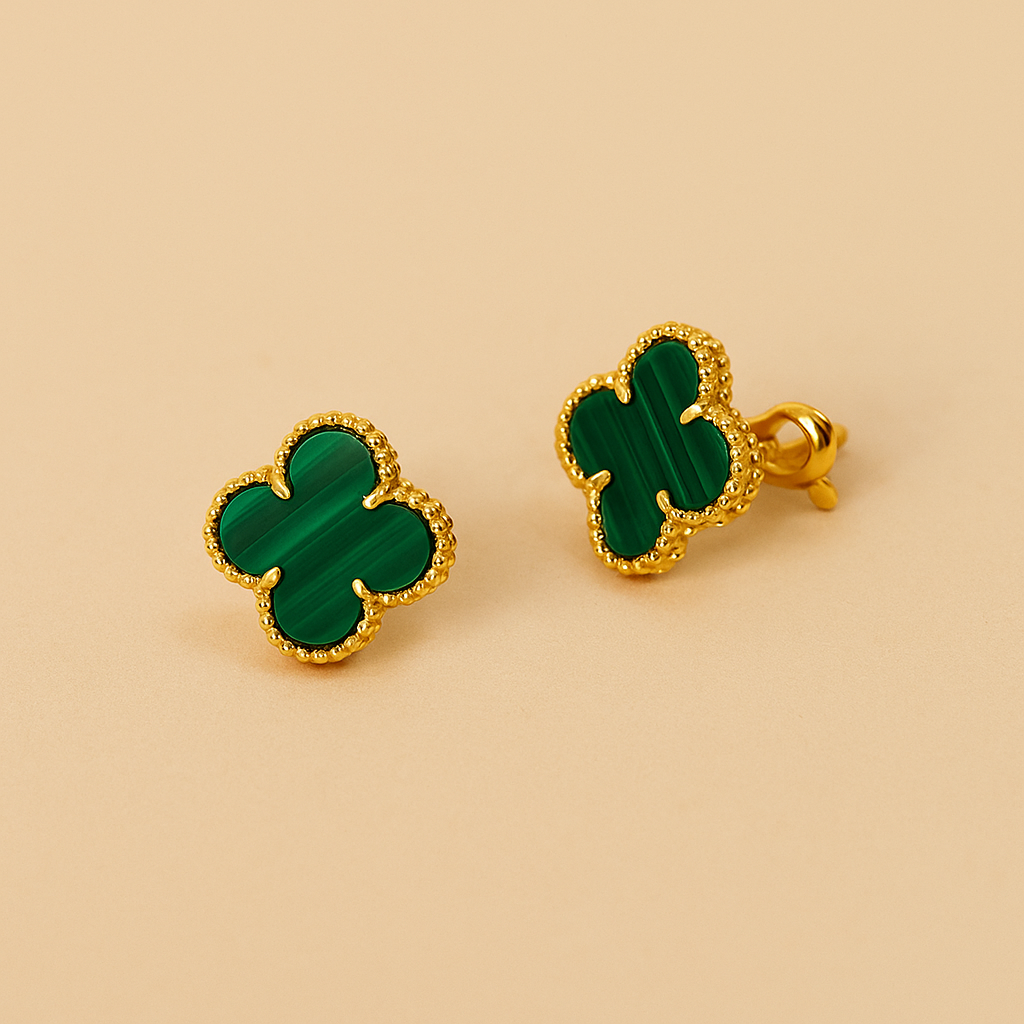 green clover-shaped earrings on a beige background