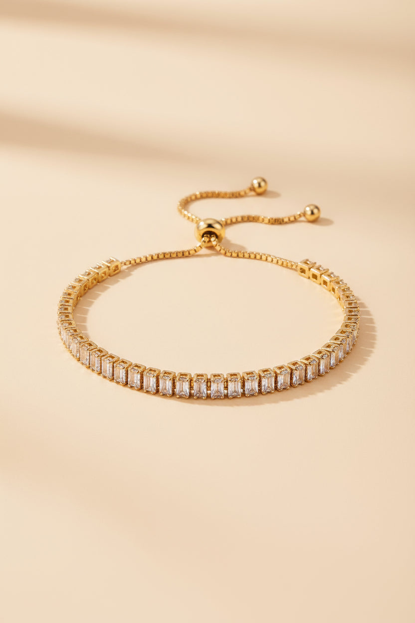 Gold bracelet with clear stones on a beige background