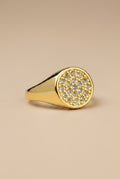 Gold ring with diamond accents on a beige background
