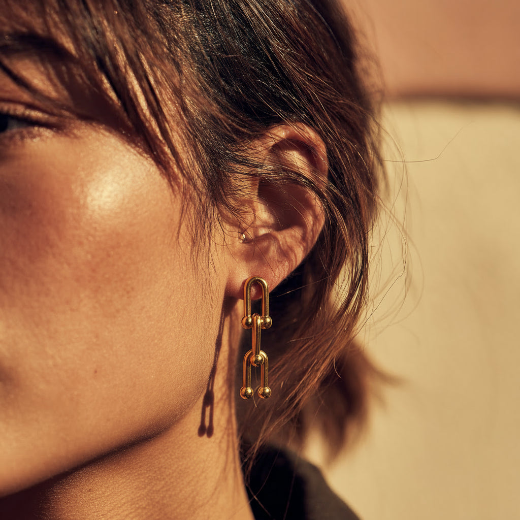 Close-up of a person wearing a gold earring with a blurred background