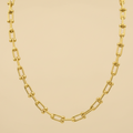 Gold chain necklace on a beige background