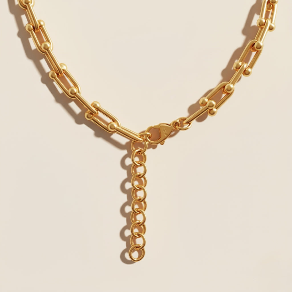 Gold chain necklace on a beige background