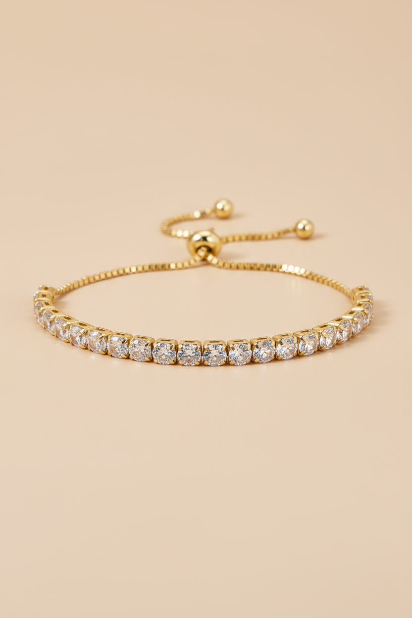 Gold bracelet with clear stones on a beige background