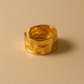 Molten Gold Ring on a beige background