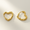 Gold heart-shaped hoop earrings on a light background