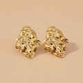 Gold earrings on a beige background