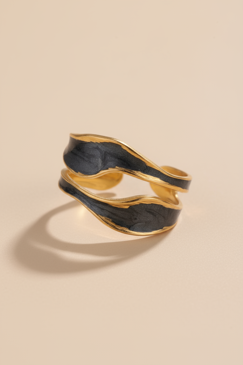 Gold and black ring on a beige background