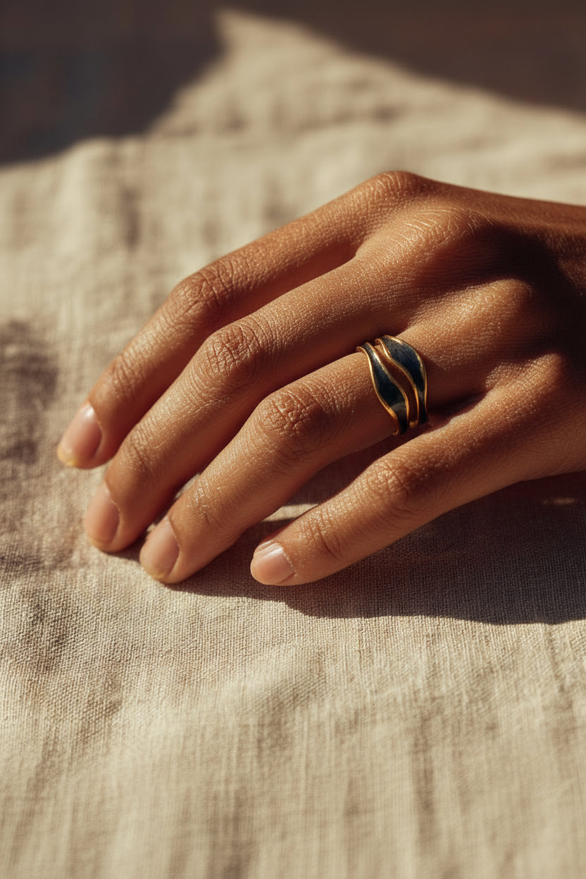 Hand wearing a ring on a textured fabric background