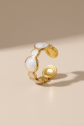 Gold ring with white stones on a beige background