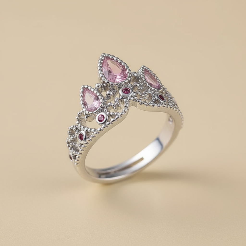 Silver ring with pink gemstones on a beige background