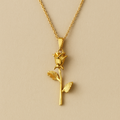 Gold rose pendant necklace on a beige background