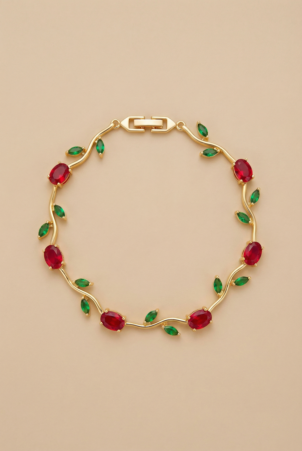 Gold bracelet with red and green gemstones on a beige background