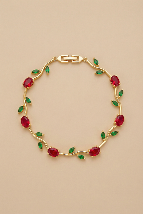 Gold bracelet with red and green gemstones on a beige background
