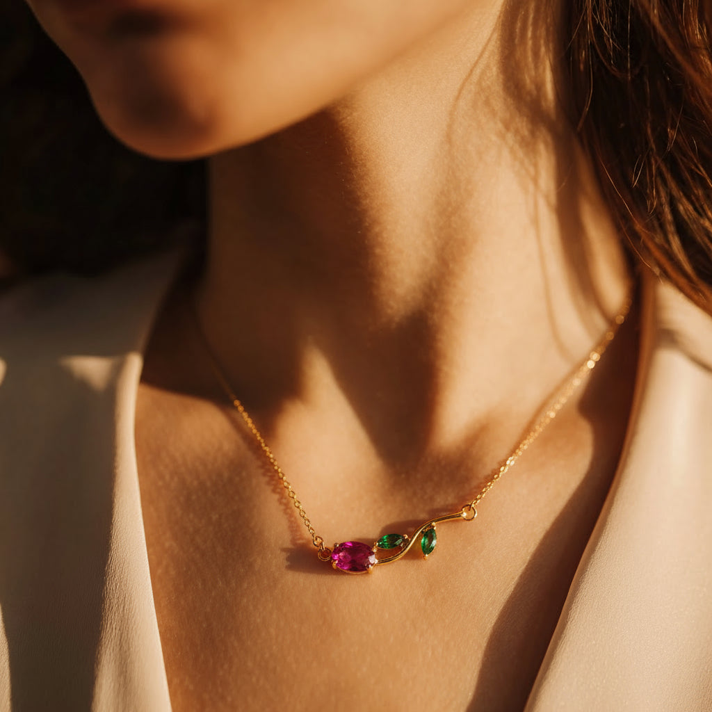 Close-up of a gold necklace with gemstones on a person's neck.