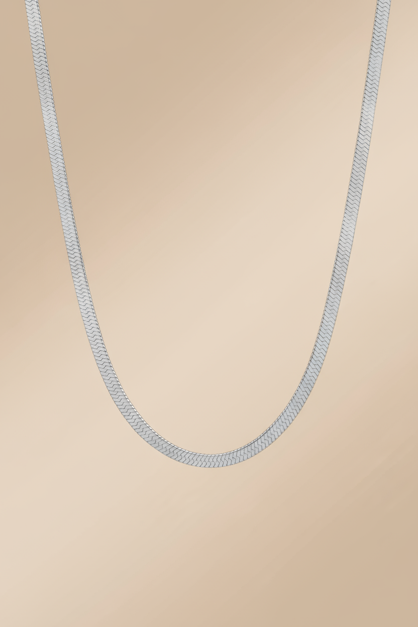 Silver chain necklace on a beige background