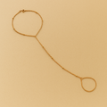 Gold Solara Handchain on a beige background