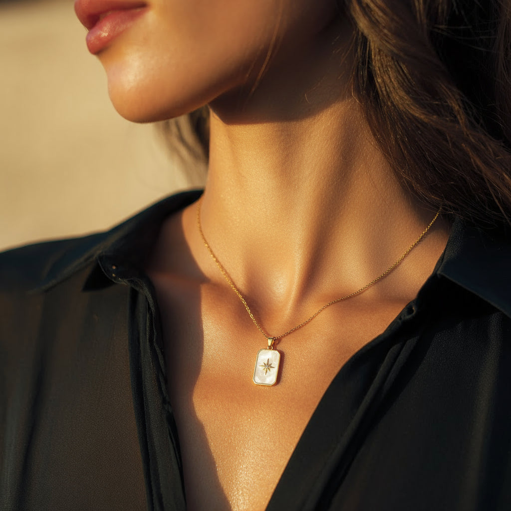 Close-up of a person wearing a gold necklace with a star pendant.