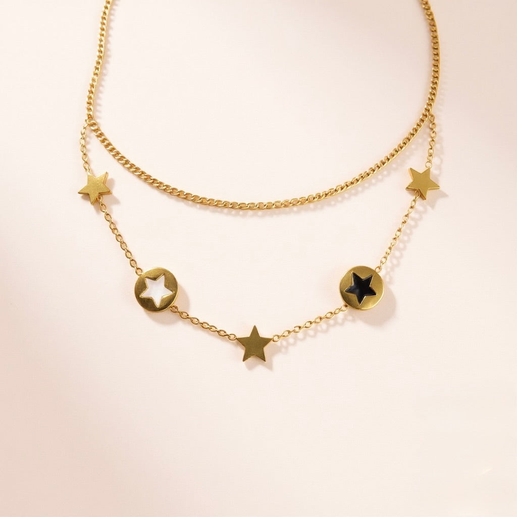 Starlight Layers Necklace with star-shaped pendants on a light beige background