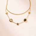 Starlight Layers Necklace with star-shaped pendants on a light beige background